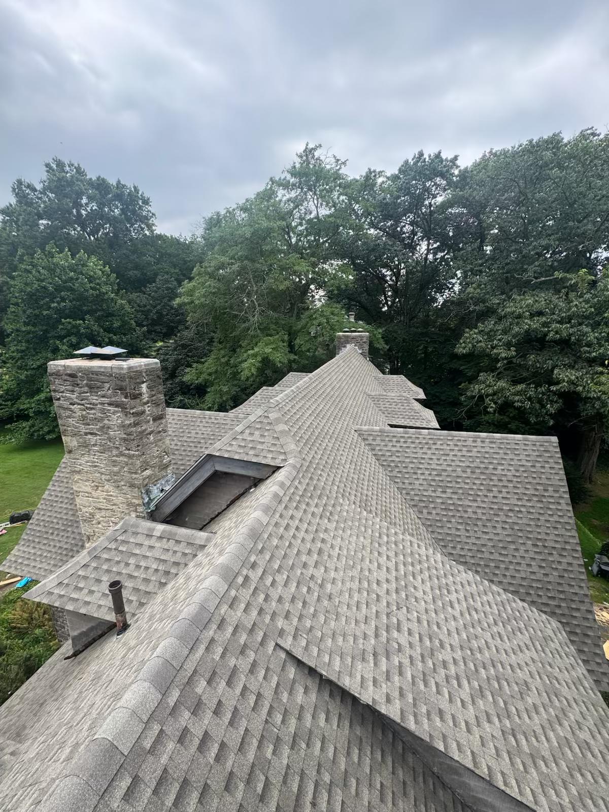 Completed grey shingle roof replacement with chimneys — NJ 2026